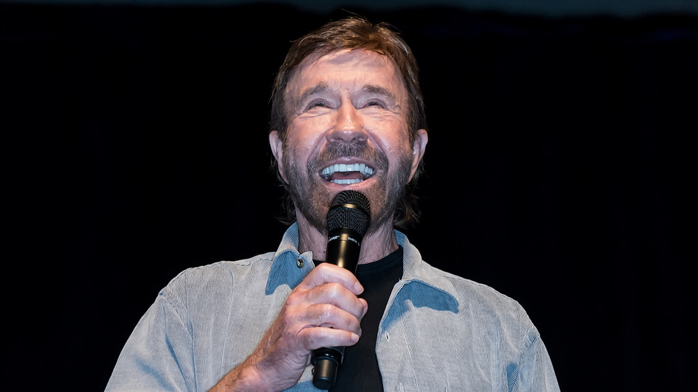 Chuck Norris speaking into microphone